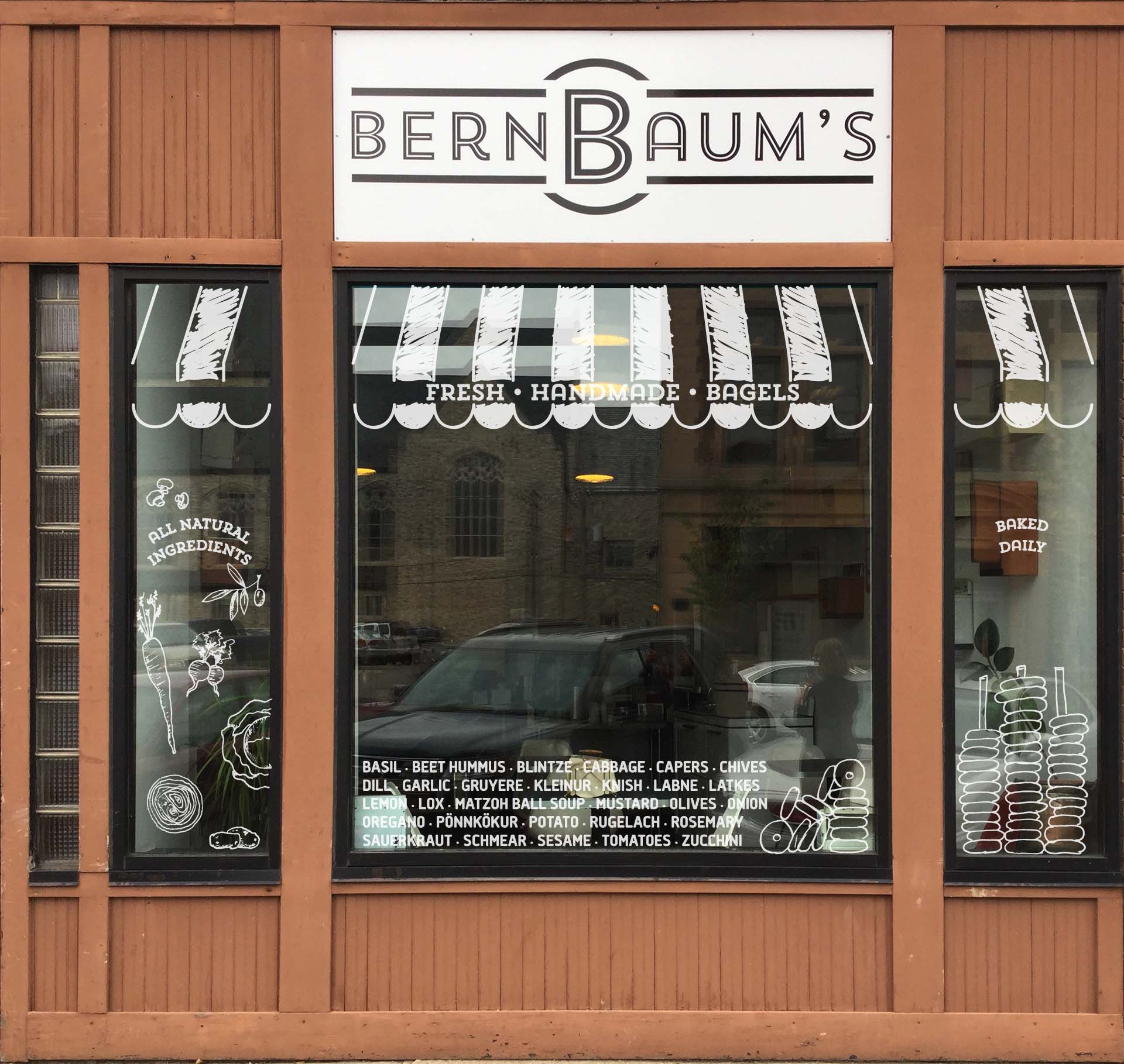 Concept for windows with hand-drawn white awning, listing of ingredients, and illustrations of ingredients and bagels