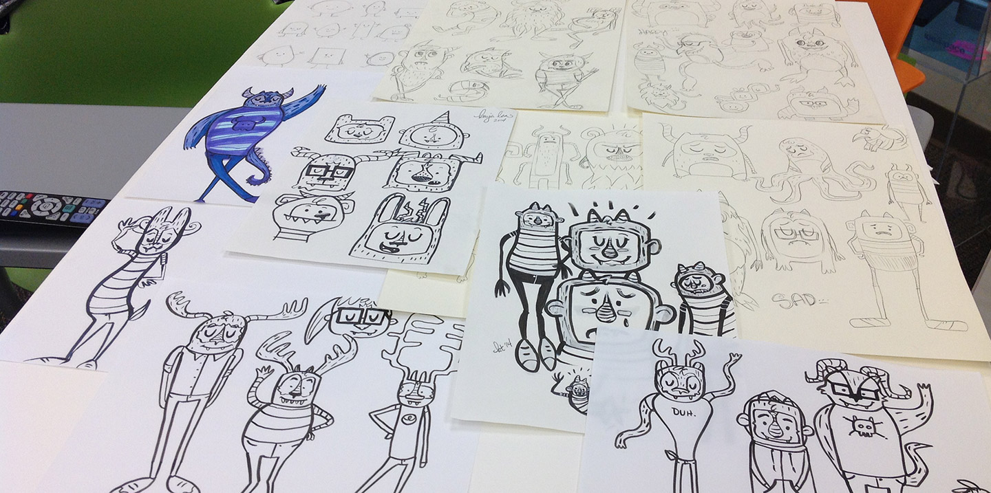 A table covered with sketches of cute monsters