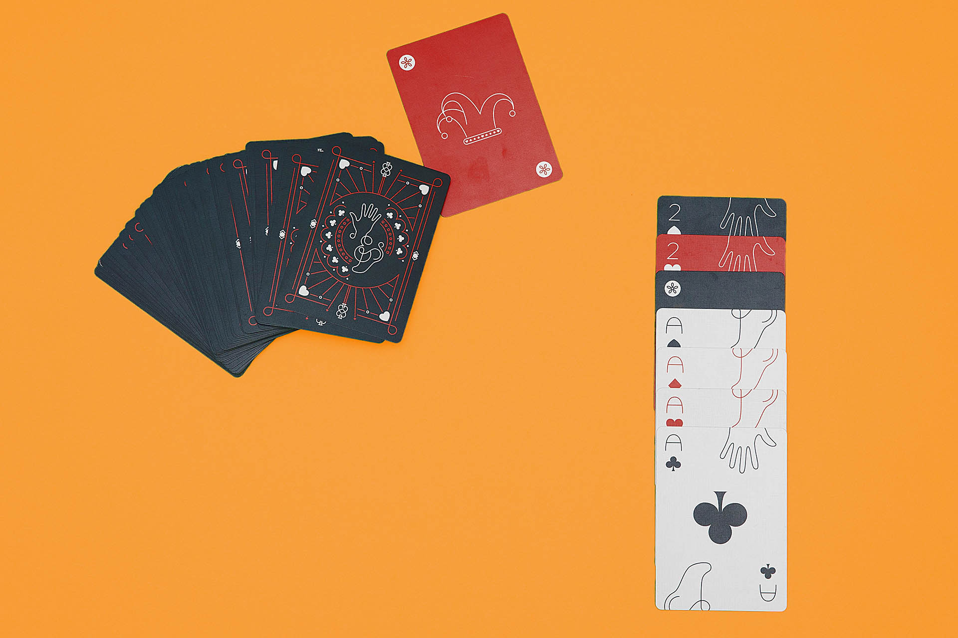 Dark gray backs of cards and a stack of aces face-up on an orange background