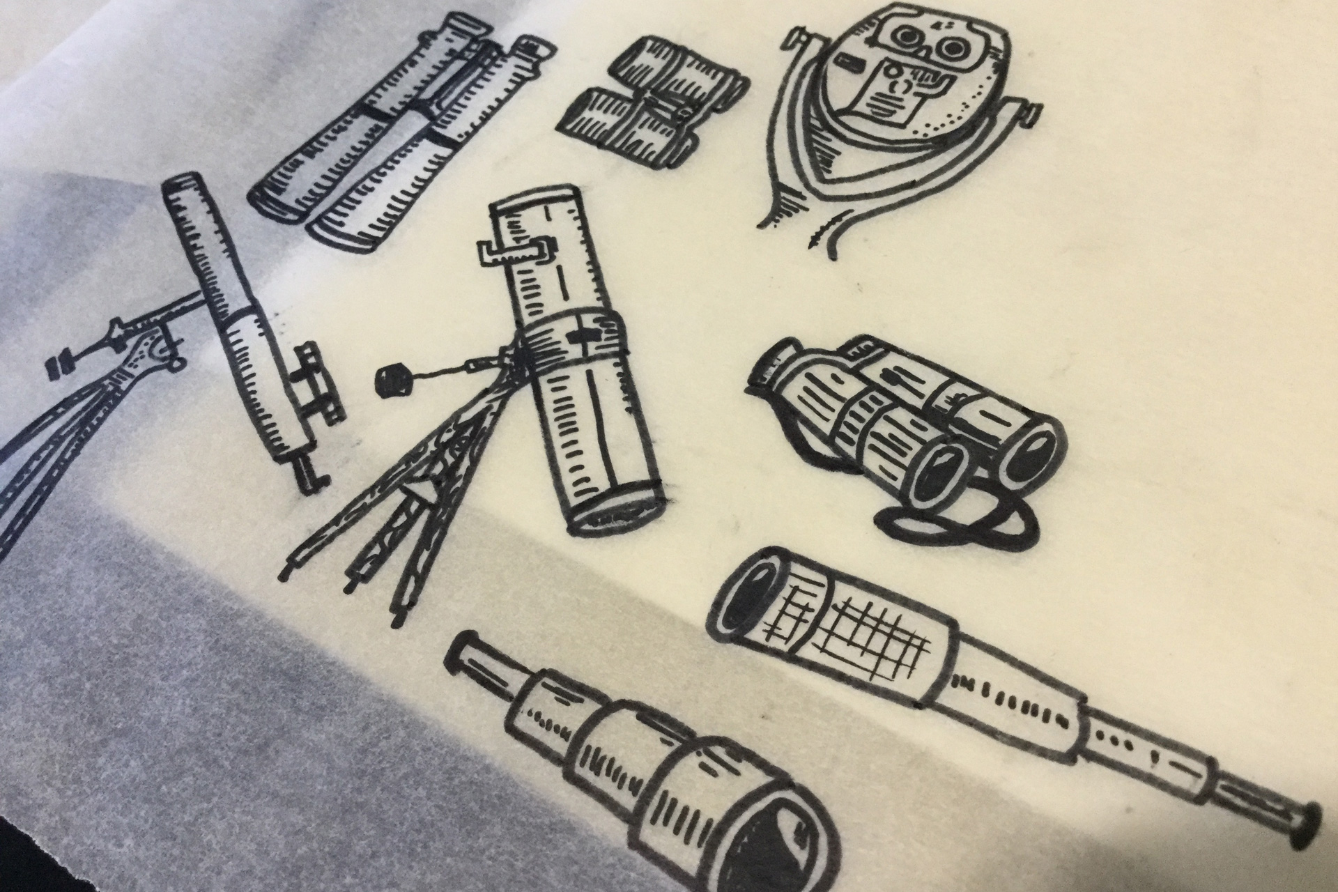 Telescopes and binoculars hand-drawn on a sheet of tracing paper