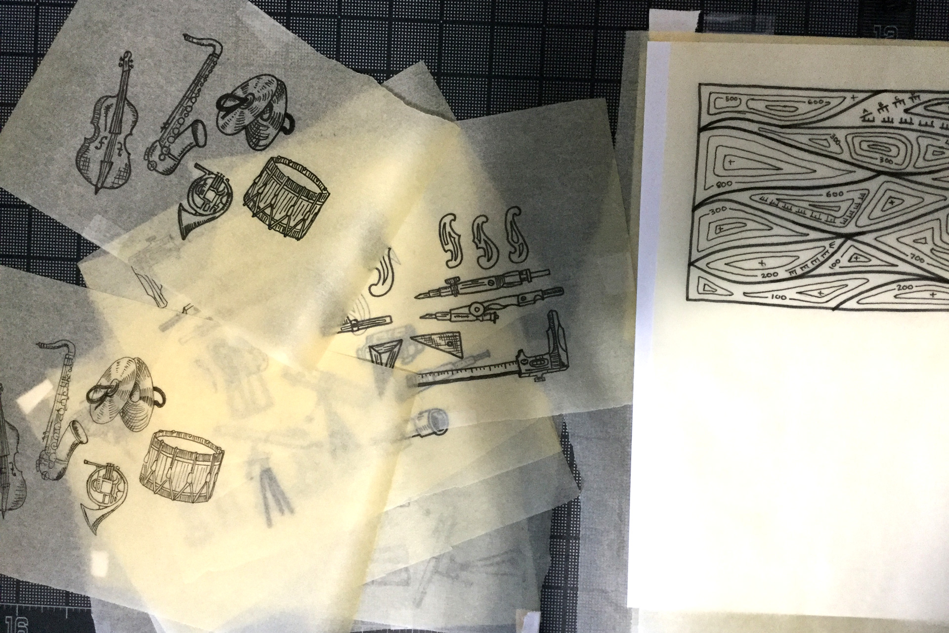 Sheets of tracing paper displaying illustrations of musical instruments