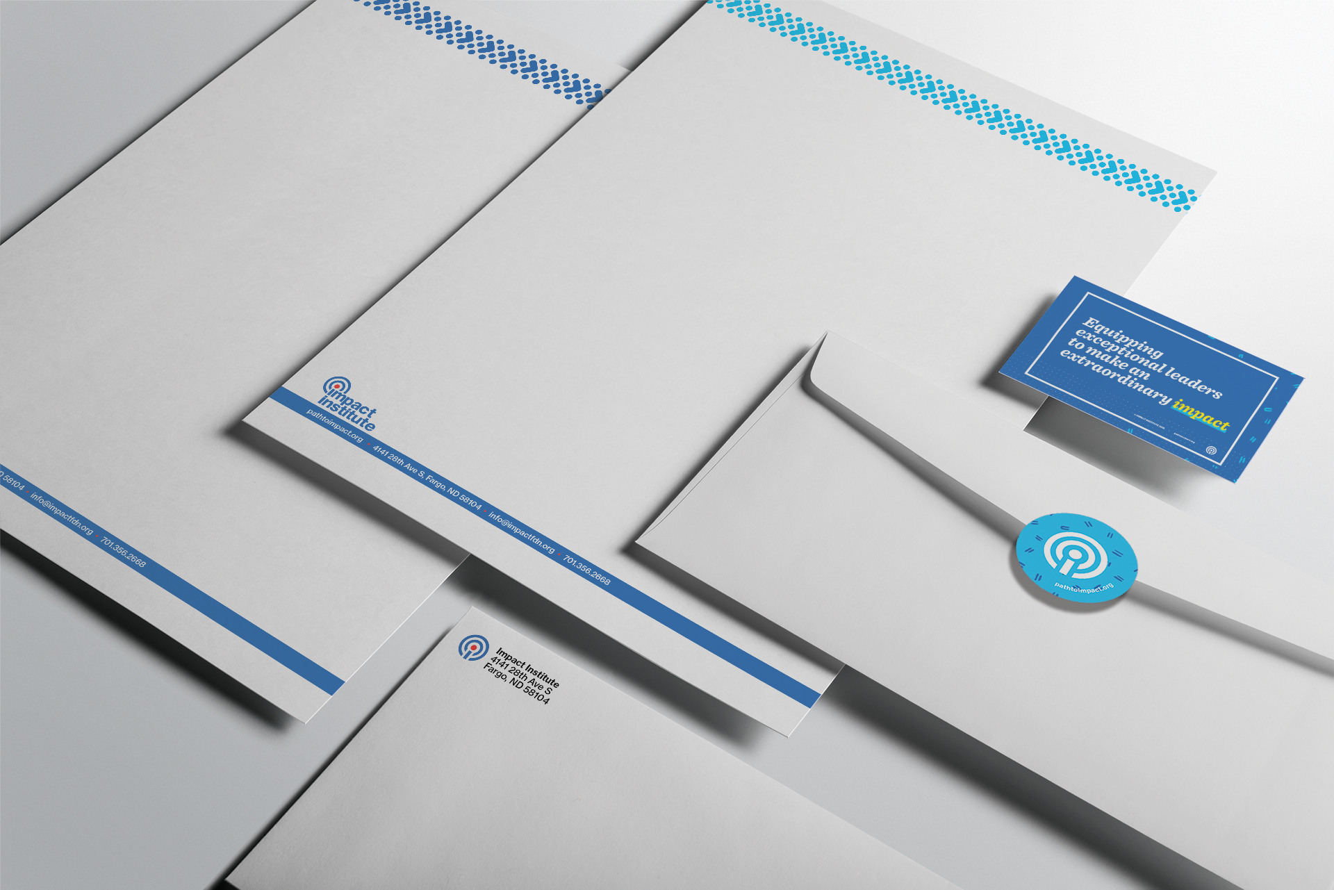 Isometric view of letterhead, envelopes, and business card for Impact Institute