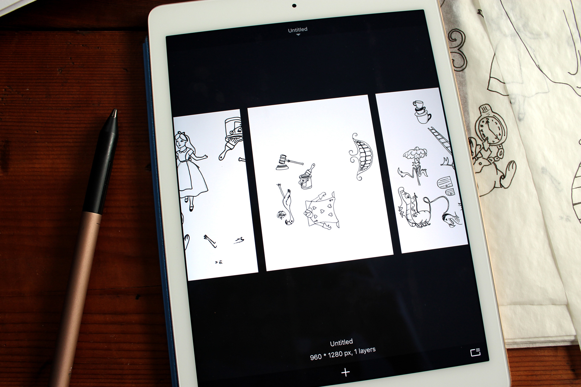 iPad showing sketches next to tracing paper and a gold stylus