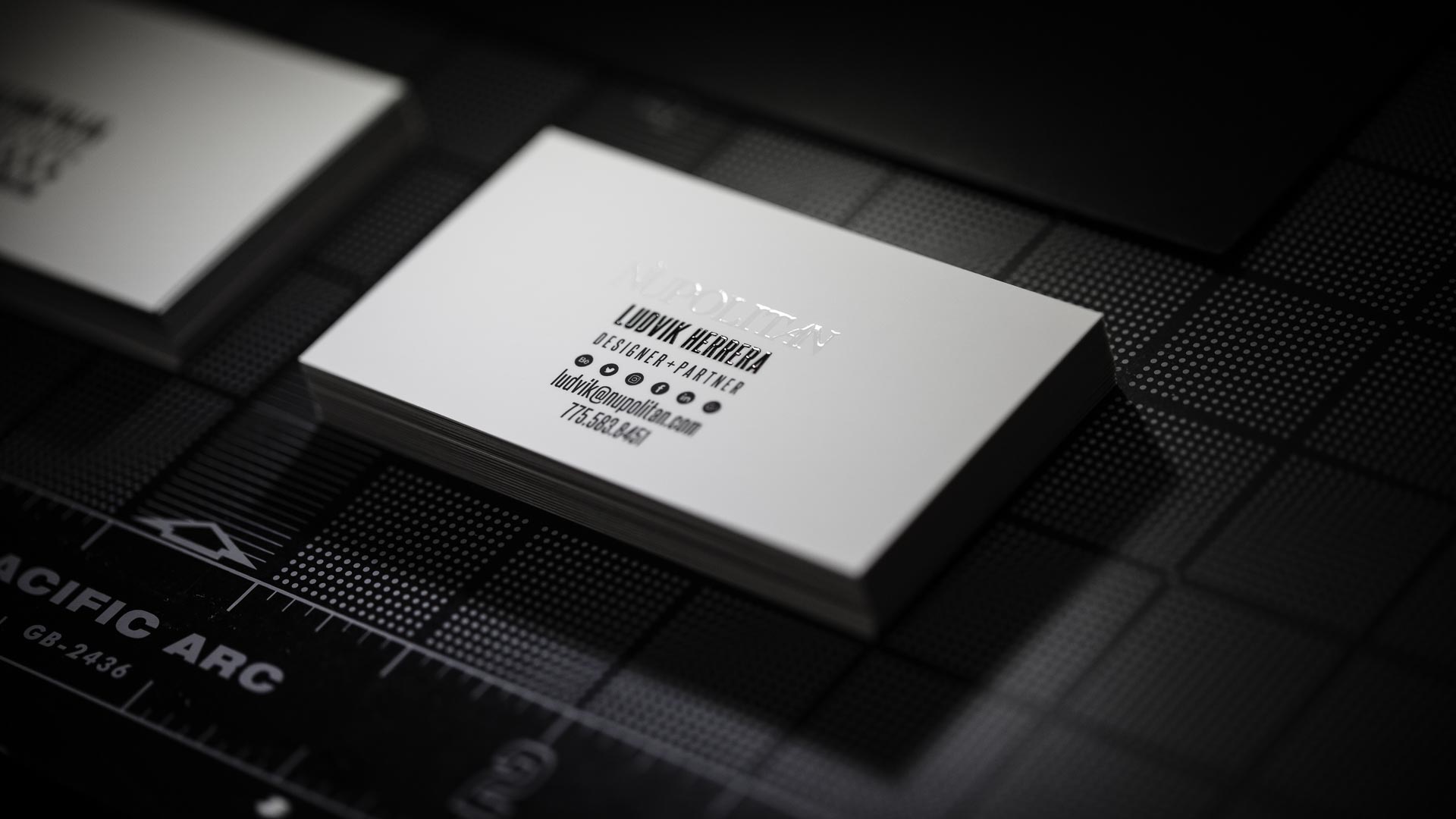 Stack of white business cards with black text and Nüpolitan printed in spot gloss