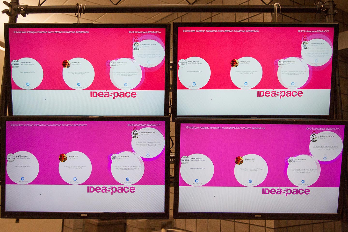 Four TV screens displaying interactive installation digital interface in pink and red