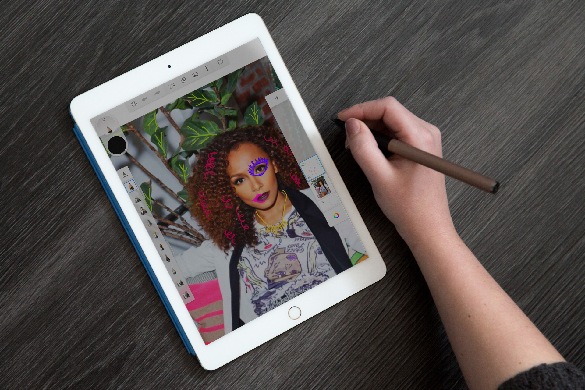 A woman's hand sketching illustrative details on an iPad