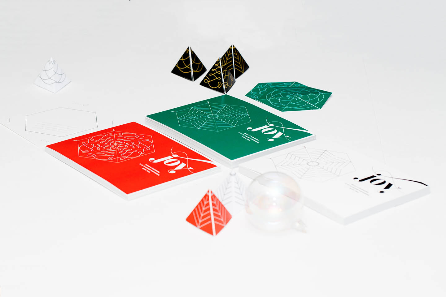 Wunderfold in its card form, punched out hexagon form, and folded 3D tree form in green, red, and black